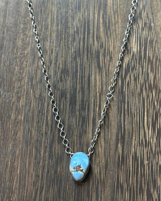 This beautiful Golden Hills Teardrop Stone Necklace features a stunning teardrop stone set in sterling silver, and comes with a 16" sterling silver chain. The necklace is also stamped with the artist's signature, G. Rios.