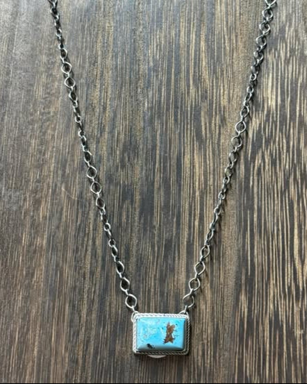 This Kingman Turquoise Bar Necklace features a stunning turquoise bar, an 18" sterling silver chain, and the signature D&D stamp.