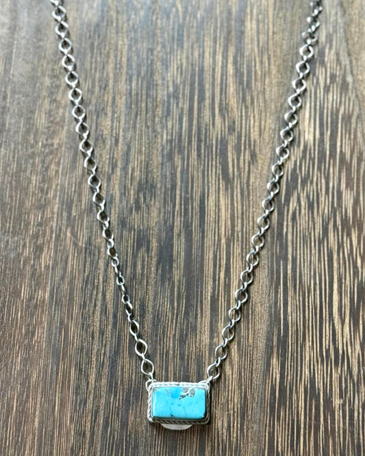 Necklace features a vibrant blue turquoise stone, expertly set in a sterling silver bar pendant.