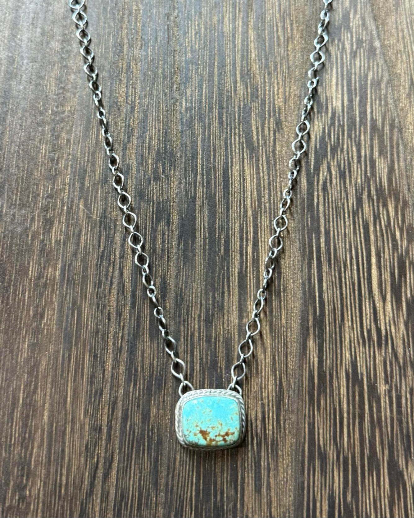 This Kingman Turquoise Bar Necklace features a stunning turquoise bar, an 18" sterling silver chain, and the signature D&D stamp.