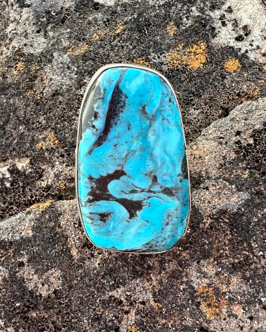 A size 6.75 sterling silver ring featuring a Kingman turquoise stone with intricate stamped detailing.