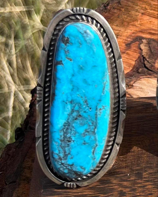 A handcrafted sterling silver ring with a vibrant Kingman turquoise stone, featuring intricate Southwestern detailing, size 8.