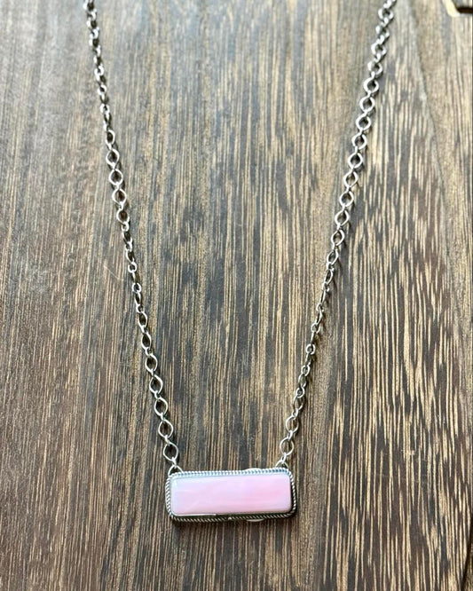 This stunning 18" sterling silver necklace features a unique pink conch shell bar pendant, accented by the delicate artistry of G. Rios's hallmark stamp.