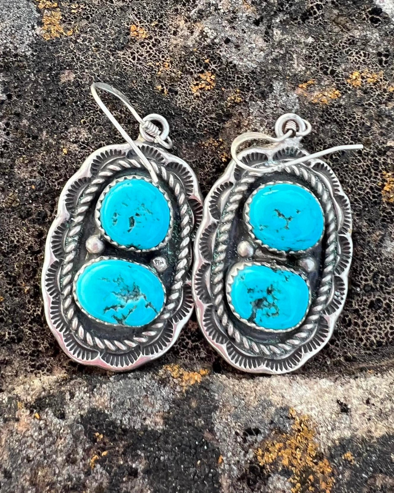 Stamped sterling silver earrings with genuine turquoise stones, featuring intricate Western-style detailing.