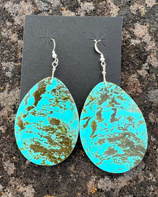 Hand-cut turquoise slab earrings with a raw, organic shape and bright blue tones.