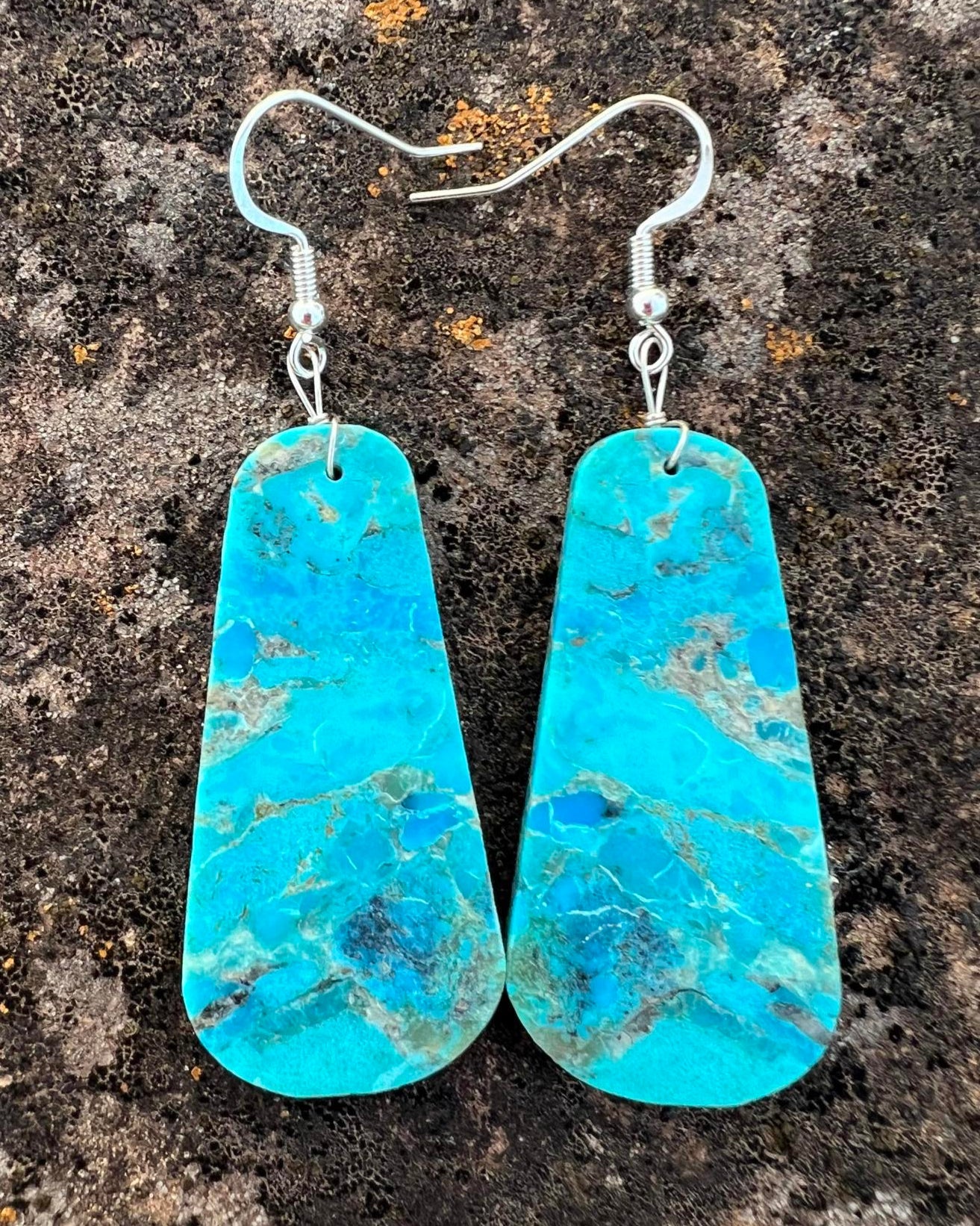 Hand-cut turquoise slab earrings with a deep blue hue and natural matrix.

