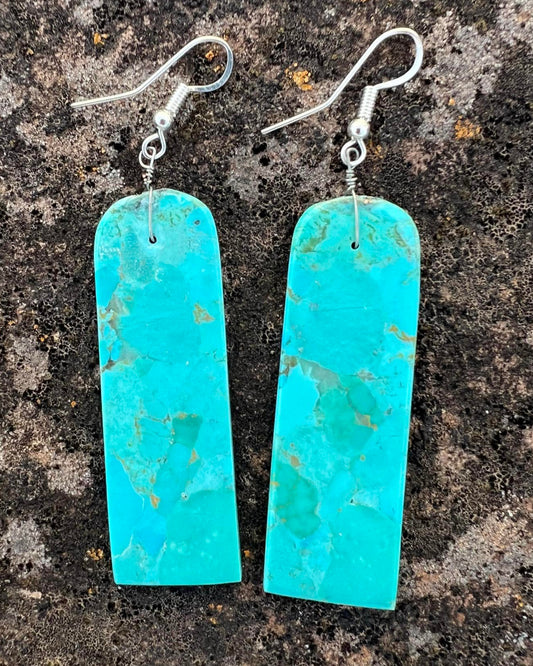 Hand-cut turquoise slab earrings with bright blue hues and raw edges.